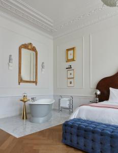 a bedroom with a tub and a bed and a mirror at Pulitzer Amsterdam in Amsterdam