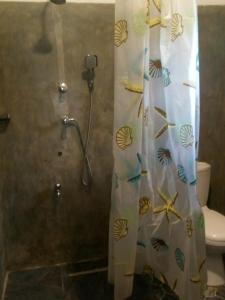 a shower curtain in a bathroom with a toilet at Sisila Villa in Bentota