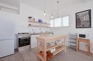 cocina con electrodomésticos blancos y mesa de madera en 13 on Main Beach Flat, en Yzerfontein 12 fotos más
