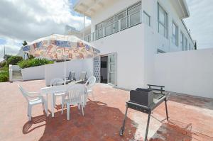 a patio with a table and chairs and an umbrella at 13 on Main Beach Flat in Yzerfontein