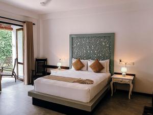 a bedroom with a large bed with a large headboard at Salt Mirissa in Mirissa