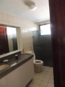 a bathroom with a toilet and a sink and a mirror at Casa do Cumbuco in Cumbuco