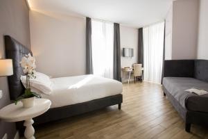 a bedroom with a bed and a couch and a table at Colosseo Prestige Rooms in Rome