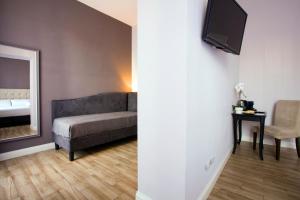 a living room with a couch and a mirror at Colosseo Prestige Rooms in Rome