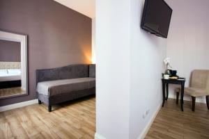 - un salon avec un canapé et un miroir dans l'établissement Colosseo Prestige Rooms, à Rome