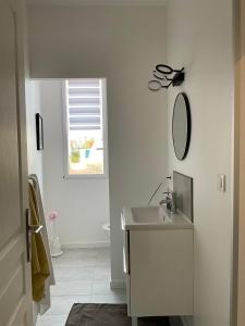 a white bathroom with a sink and a mirror at T2 stylé/calme et confortable in Arcachon