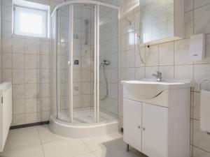 baño blanco con ducha y lavamanos en Hotel A8 Lukas, en Augsburg