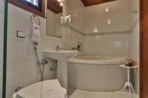 a bathroom with a sink and a tub and a toilet at Pousada Jardon Campos do Jordão - Exclusiva para Adultos in Campos do Jordão +15 photos
