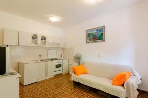 a living room with a couch and a kitchen at Apartments Katica's Place in Prizba
