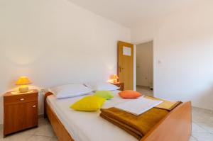 Un dormitorio con una cama con almohadas de colores. en Apartments Katica's Place, en Prizba