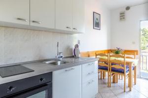 cocina blanca con fregadero y mesa en Apartments Katica's Place, en Prizba