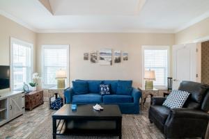 a living room with a blue couch and a table at Island House 1Bu By Pkrm in Pensacola