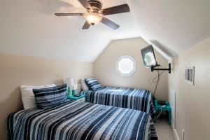 two beds in a room with a ceiling fan at Island House 1Bu By Pkrm in Pensacola +32 photos
