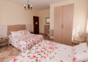 a bedroom with two beds and a dresser at Hostal Sonrisa del Mar in Conil de la Frontera