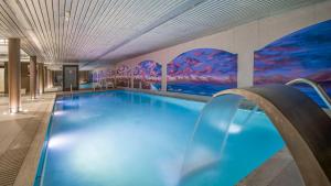 a large swimming pool with a mural on the wall at Roc Blanc Hotel & Spa in Andorra la Vella