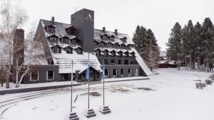 un edificio en la nieve con terrenos cubiertos de nieve en Amérian Aluminé, en Aluminé