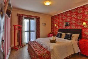 um quarto com uma cama grande e papel de parede vermelho em Pousada Jardon em Campos do Jordão