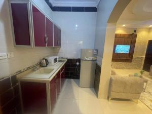 a small kitchen with a sink and a microwave at Admire Apart' Hotel - Jeddah in Jeddah