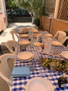 a table with plates of food and a laptop on it at Adults only Beachhouse Pineto zona Corfu in Pineto