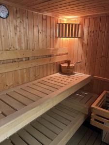 a wooden sauna with a wooden tub with a clock at Boska Osada in Czarna Góra