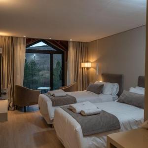 Una habitación de hotel con dos camas y una ventana. en Amérian Aluminé, en Aluminé