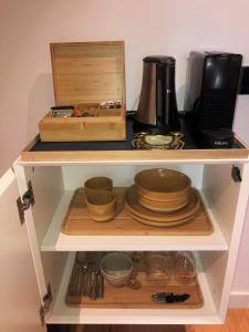 a shelf with bowls and utensils and a box at 23 SouS in Amsterdam