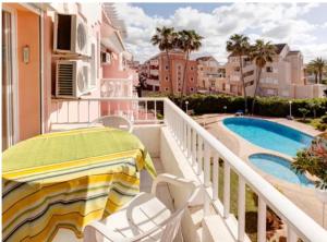 a balcony with a table and chairs and a swimming pool at Los Jasminez in Denia