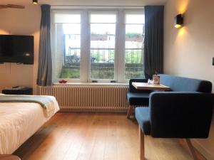 a hotel room with a bed and a desk and a window at 23 SouS in Amsterdam