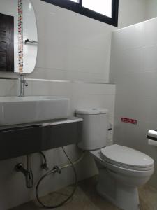 a bathroom with a toilet and a sink and a mirror at เคียงภูวิลล่า in Sangkhom