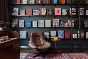 بوليتزر أمستردام في أمستردام: غرفة بها كرسي وحجز رفوف مع كتب