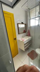 a bathroom with a yellow door and a sink at KIT COMPLETO LAPA IDEAL PARA TURISMO in Rio de Janeiro