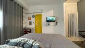 a bedroom with a bed and a tv on the wall at KIT COMPLETO LAPA IDEAL PARA TURISMO in Rio de Janeiro
