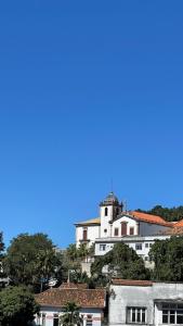 a white building on top of a hill with trees at KIT COMPLETO LAPA IDEAL PARA TURISMO in Rio de Janeiro