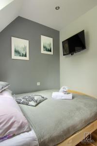 a bedroom with a bed and a flat screen tv at Domek u Justyny in Kościelisko