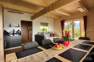 a dining room with a table and a kitchen at Domek u Justyny in Kościelisko