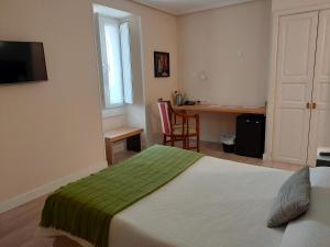 a bedroom with a bed with a green blanket at Hotel Arrope in Haro