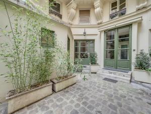 a building with a green door and some plants at Confortable appartement pour 4 pers à Paris by Weekome in Paris