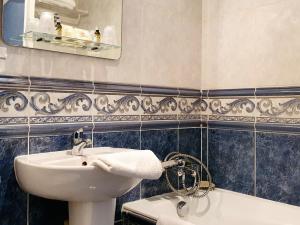 uma casa de banho com um lavatório, um WC e um espelho. em Hôtel Restaurant Ferme de la Grande Cour em Honfleur