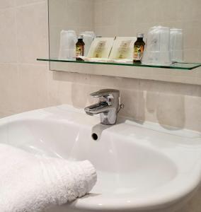 um lavatório de casa de banho com uma torneira e uma toalha em Hôtel Restaurant Ferme de la Grande Cour em Honfleur