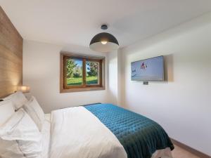 sypialnia z łóżkiem, oknem i telewizorem w obiekcie Appartement de Standing à Megève, 5 Min des Pistes, Sauna, Hammam, Parking, Animaux Acceptés - FR-1-569-52 w mieście Megève