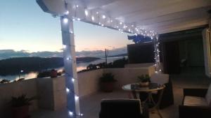 un patio con una serie de luces en un balcón en Casa para ti en Porto Heli