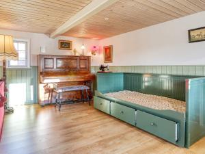 um quarto com uma cama e um piano em Holiday home Læsø LIII em Læsø