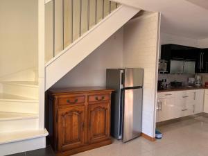 una cocina con nevera de acero inoxidable y una escalera en Gite en Normandie, en Rugles
