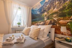 a bedroom with two swans towels on a bed at Apartament Dworzec Tatrzański in Zakopane