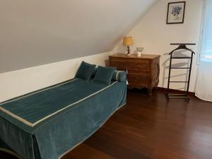 1 dormitorio con 1 cama verde y suelo de madera en Gite en Normandie, en Rugles