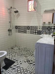La salle de bains est pourvue d'un lavabo et de toilettes. dans l'établissement Maison Oceane a Zac MBAO, à Kammba