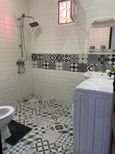 a bathroom with a sink and a toilet at Maison Oceane a Zac MBAO in Kammba +15 photos