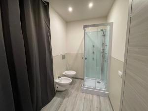 uma casa de banho com uma cabina de duche em vidro e um WC. em Rent room Iacopo em Capannori