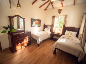 a bedroom with two beds and a mirror at Nicawaves in Popoyo