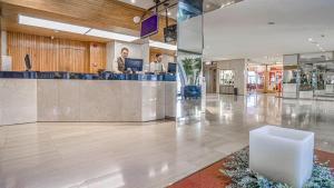 a lobby with two people working at a counter at Roc Blanc Hotel & Spa in Andorra la Vella